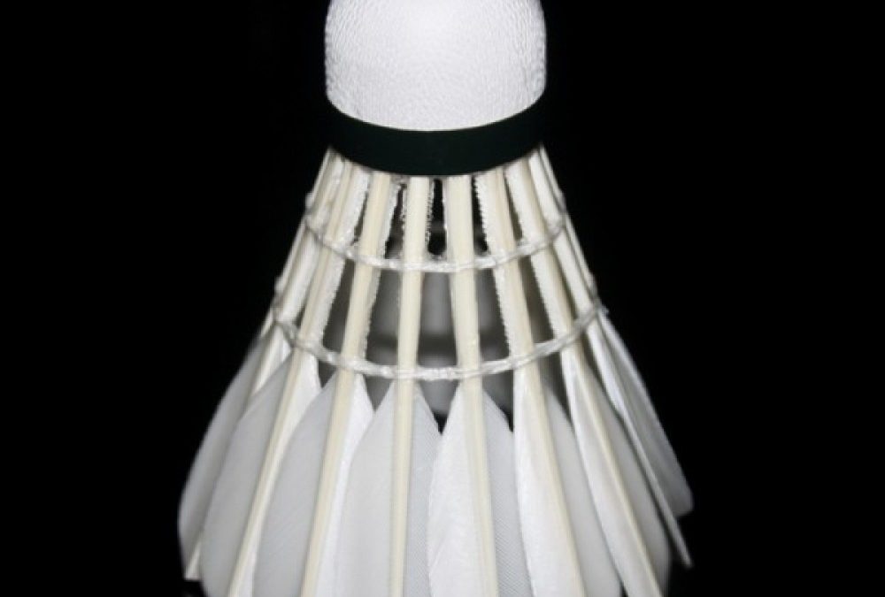 An image of a white badminton shuttlecock on a black background.