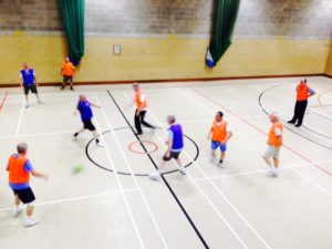 A group of men play a game of walking football.