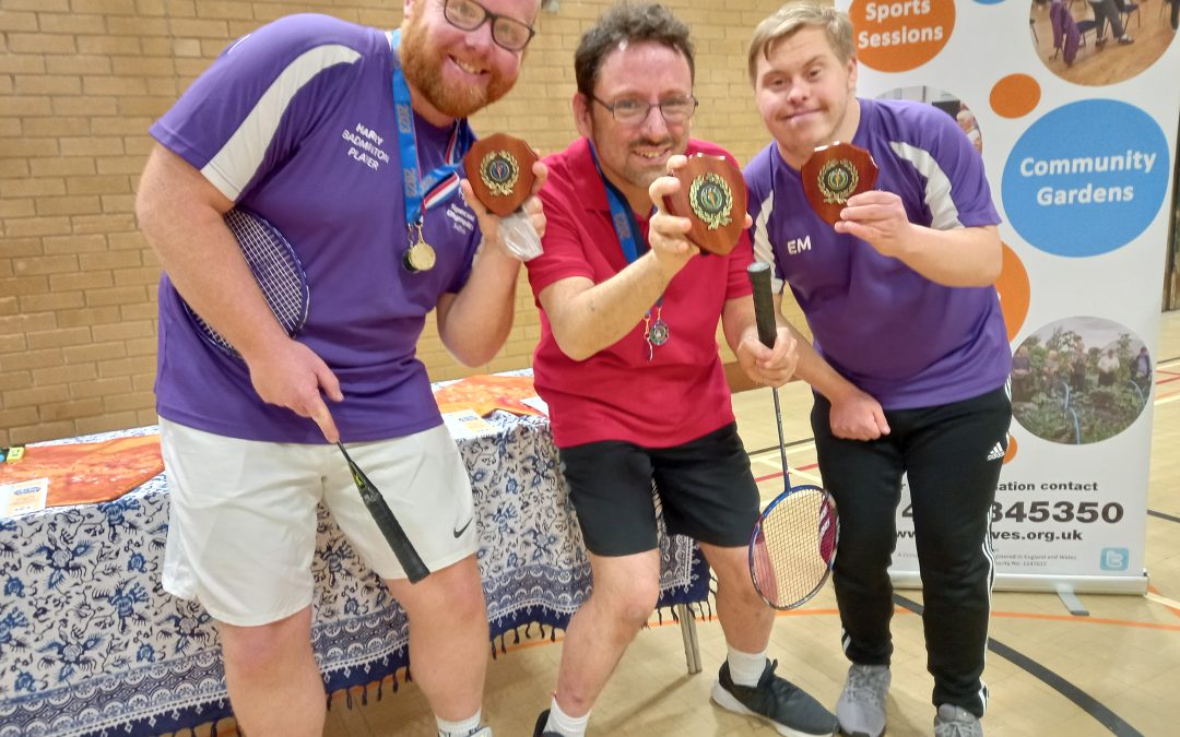 Three badminton players show off their winners medals and trophies at the recent badminton tournament.