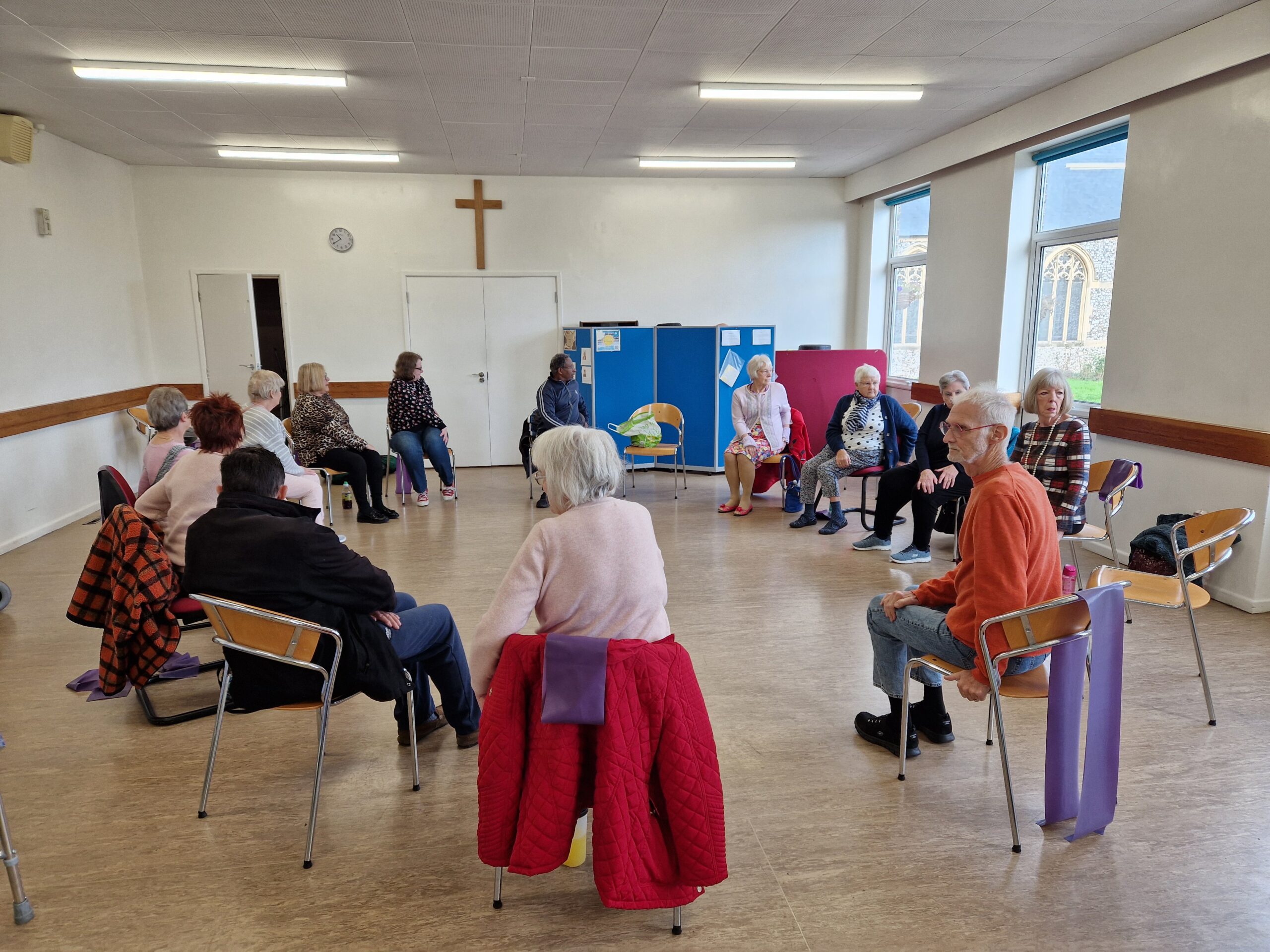 Members of the lunch club doing their regular exercise inside a hall