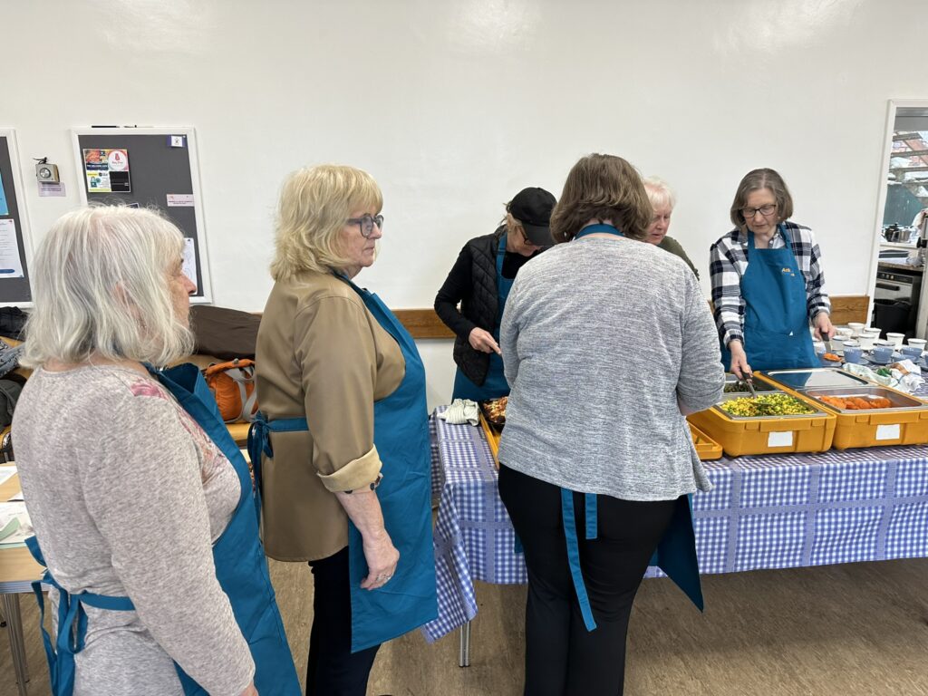 Volunteers preparing the meals to be served to lunch club members