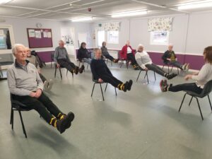 A group of Better Balance members doing a seated exercise with an instructor