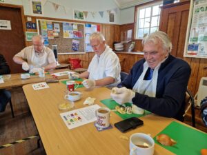 Members of Men's Breakfast Hub slicing vegetables during a soup making activity