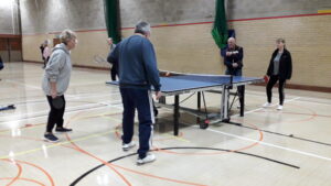 Two Players playing Ping Pong inside a sports centre