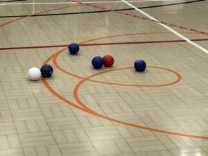 Boccia balls on the floor with blue, red and white colours